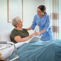 nurse with elder in bed