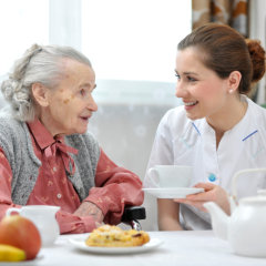 nurse talking to elder in table