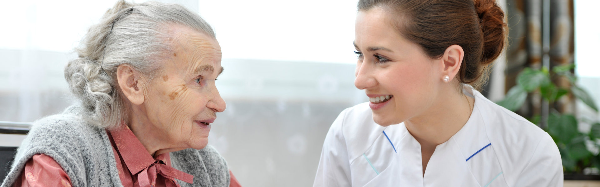 nurse and elder talking in table